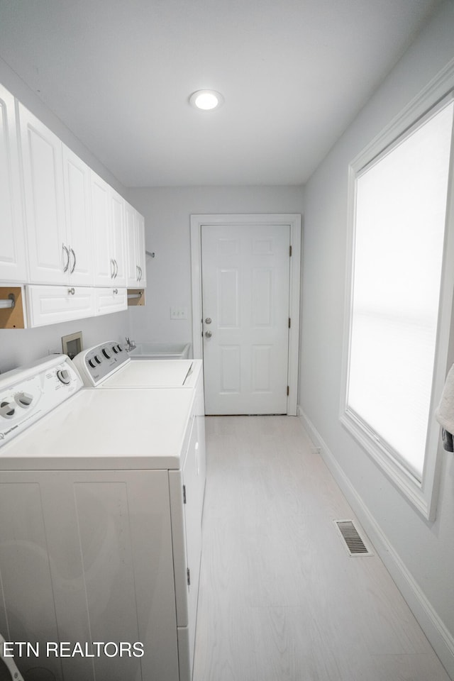 laundry room featuring cabinets and separate washer and dryer