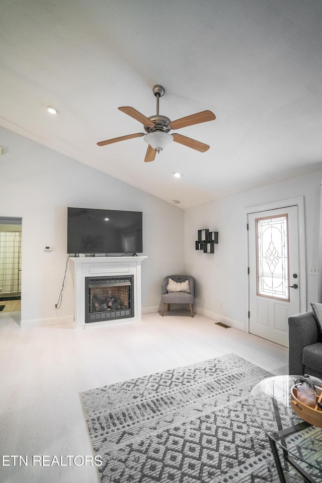 living room with vaulted ceiling, light wood-type flooring, and ceiling fan