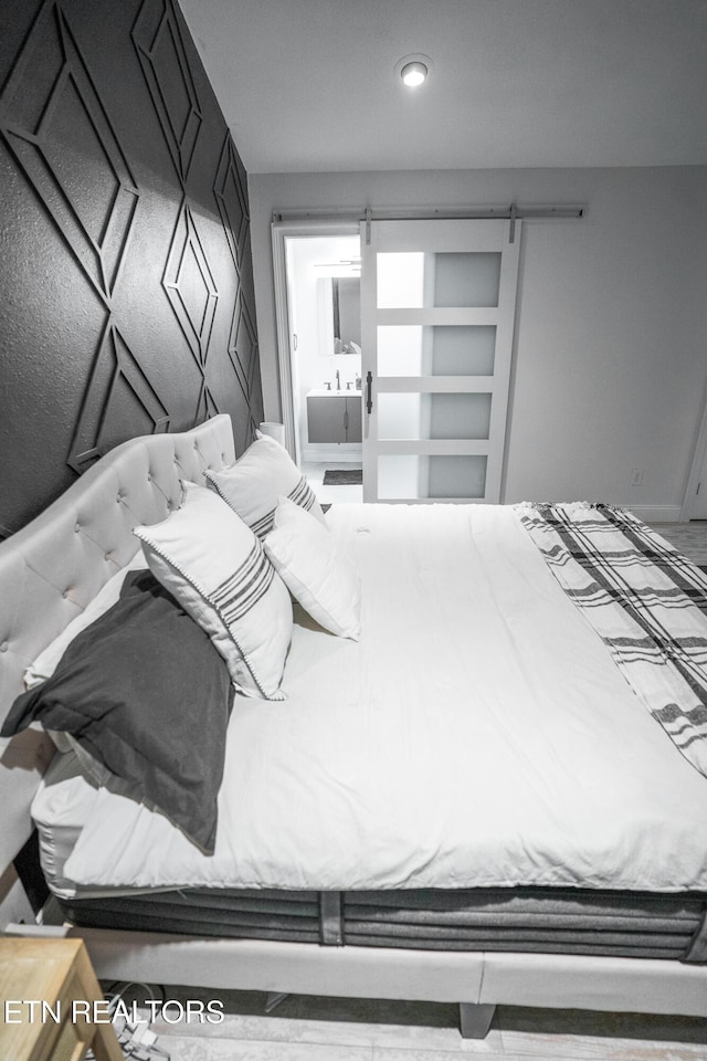 bedroom with connected bathroom and a barn door