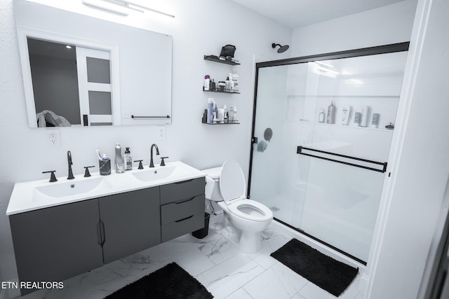 bathroom featuring vanity, a shower with door, and toilet