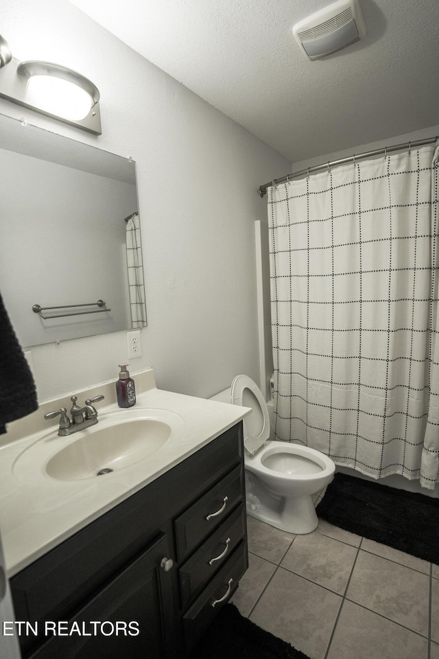 full bathroom featuring toilet, a textured ceiling, vanity, shower / bath combo, and tile patterned flooring