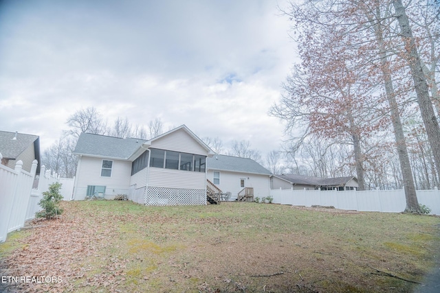 back of property with a lawn and a sunroom