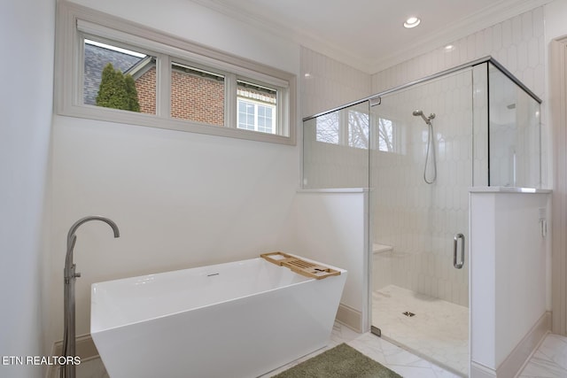 bathroom with baseboards, a freestanding bath, marble finish floor, ornamental molding, and a shower stall