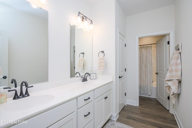 bathroom with hardwood / wood-style flooring, vanity, and shower / bath combo