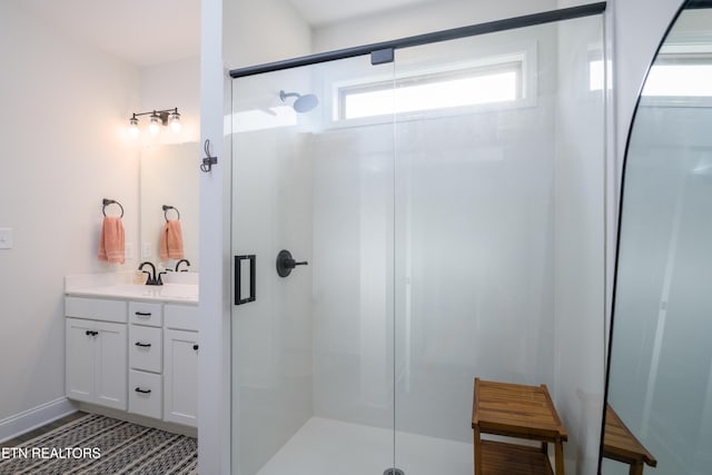 bathroom featuring an enclosed shower and vanity