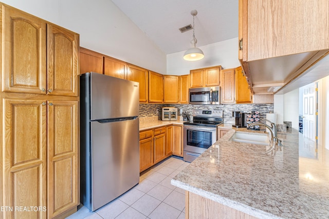 kitchen featuring sink, hanging light fixtures, stainless steel appliances, light stone countertops, and decorative backsplash