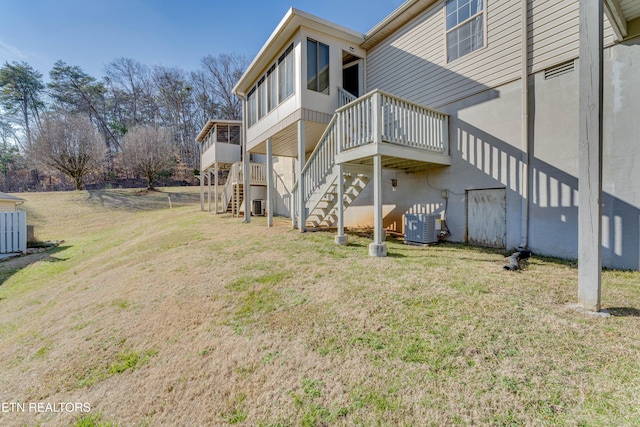 back of house with central AC unit and a lawn