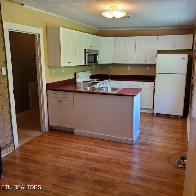 kitchen with white appliances, light hardwood / wood-style flooring, ornamental molding, and white cabinets