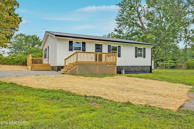 view of front of property with a deck and a front lawn