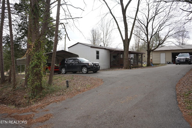 view of front of house featuring a carport, a garage, and an outdoor structure