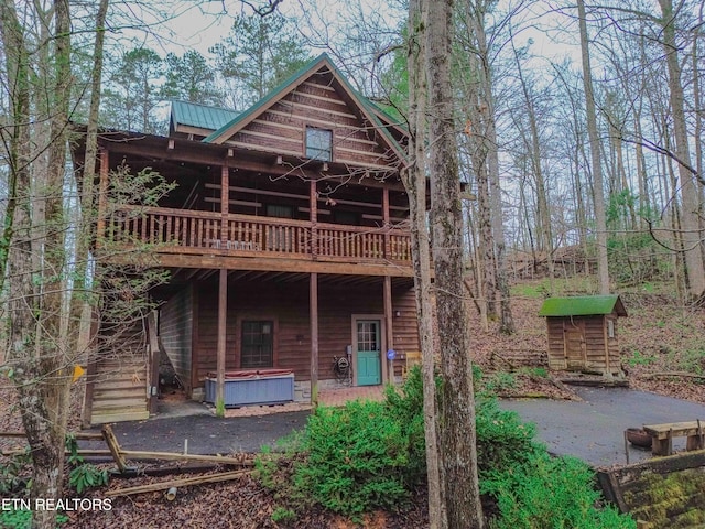 rear view of house with a hot tub