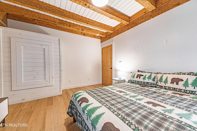 bedroom with wood ceiling, beam ceiling, and light hardwood / wood-style floors