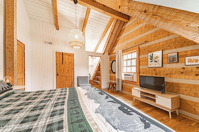 bedroom with beamed ceiling, hardwood / wood-style floors, wooden walls, and cooling unit