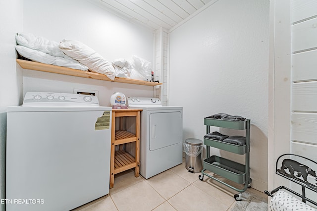 clothes washing area featuring light tile patterned flooring and separate washer and dryer