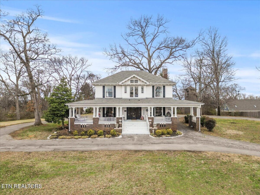 farmhouse-style home with a porch and a front yard