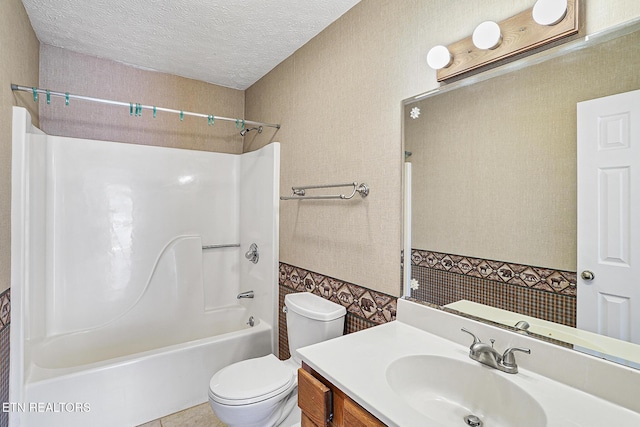 full bathroom featuring vanity, bathtub / shower combination, toilet, and a textured ceiling