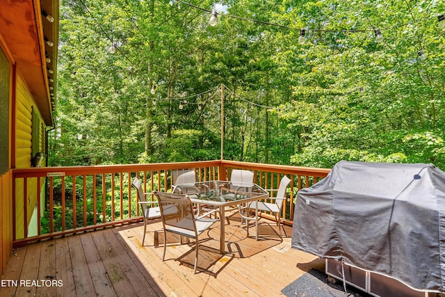 1521 Dawn Ln, Sevierville, TN 37876 - wooden terrace featuring outdoor dining space, grilling area, and a view of trees