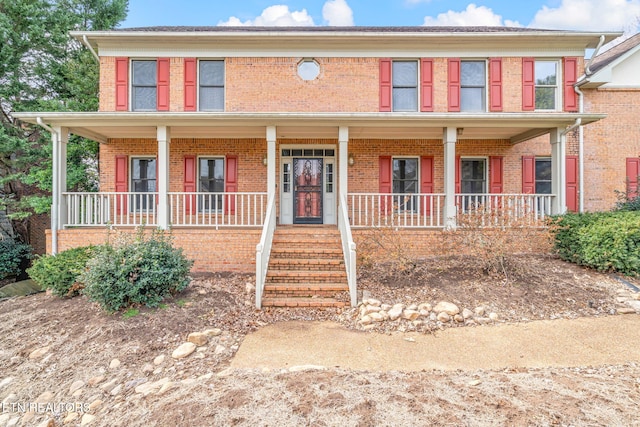 view of front facade with brick siding and a porch