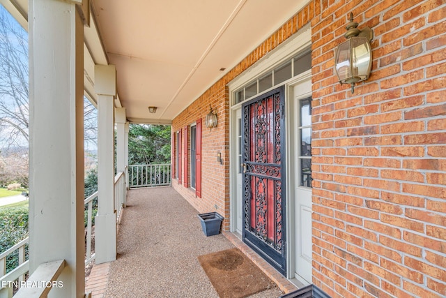 property entrance featuring brick siding and covered porch