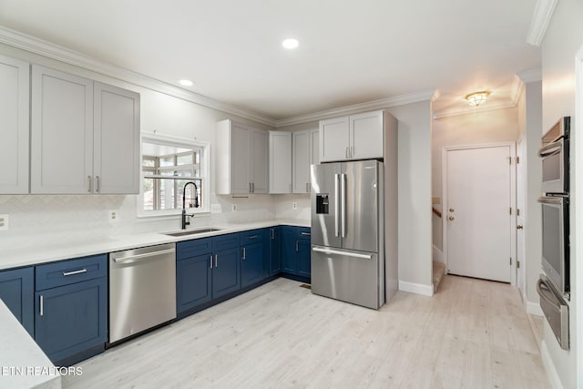 kitchen featuring backsplash, light countertops, ornamental molding, appliances with stainless steel finishes, and a sink