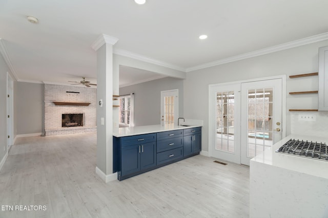 kitchen featuring blue cabinetry, ceiling fan, ornamental molding, and light wood finished floors