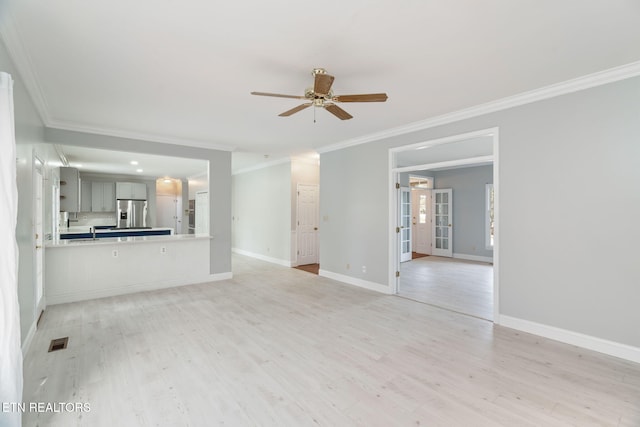 unfurnished living room with visible vents, a ceiling fan, crown molding, light wood finished floors, and baseboards