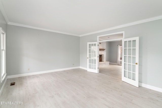 spare room with light wood-style flooring, french doors, baseboards, and ornamental molding