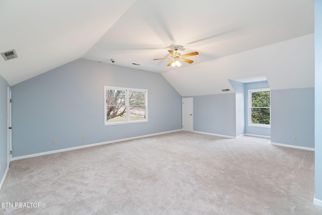 additional living space featuring visible vents, a healthy amount of sunlight, baseboards, and vaulted ceiling