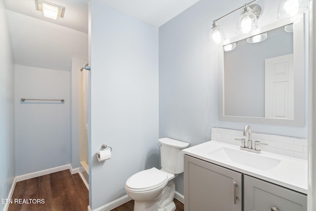 bathroom featuring toilet, backsplash, wood finished floors, a shower with shower curtain, and vanity