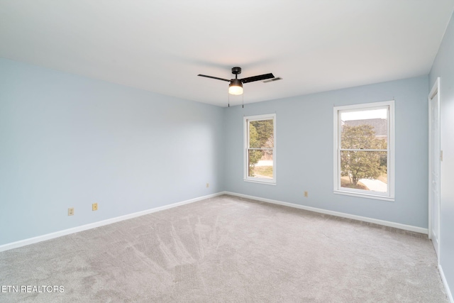 carpeted spare room with baseboards and ceiling fan