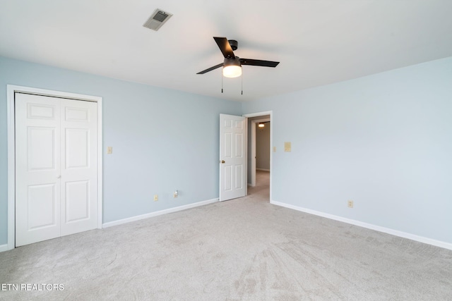 carpeted spare room featuring visible vents, baseboards, and ceiling fan