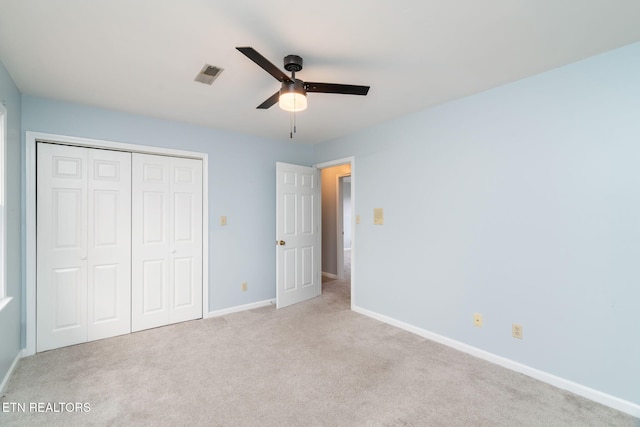 unfurnished bedroom featuring a ceiling fan, carpet, visible vents, baseboards, and a closet