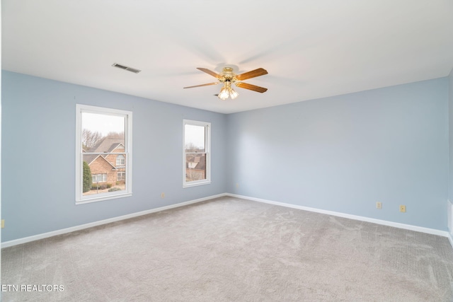 empty room with visible vents, baseboards, carpet flooring, and a ceiling fan