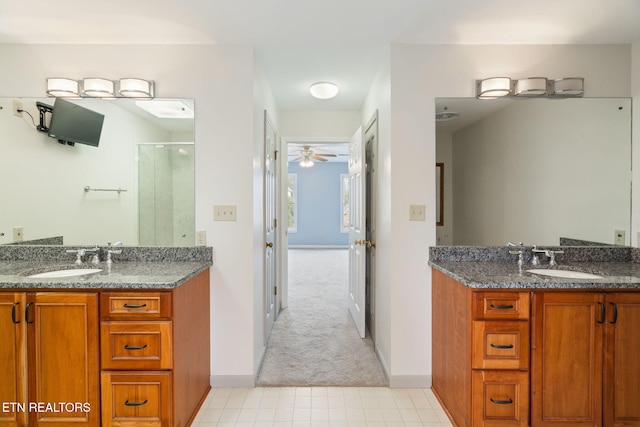 bathroom with a shower stall, two vanities, and a sink