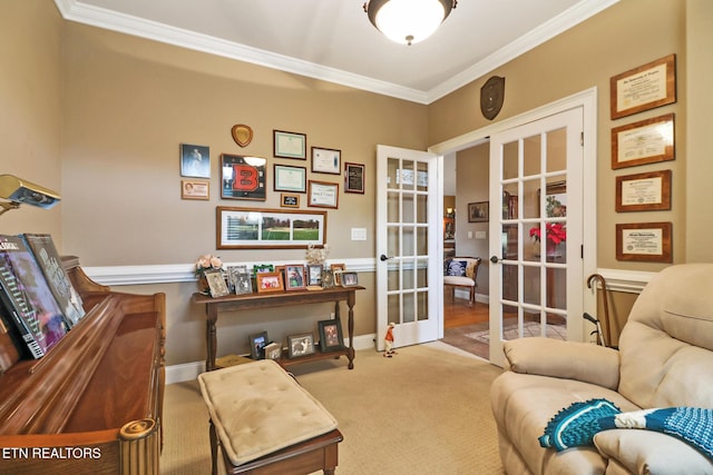 sitting room with carpet floors, ornamental molding, and french doors