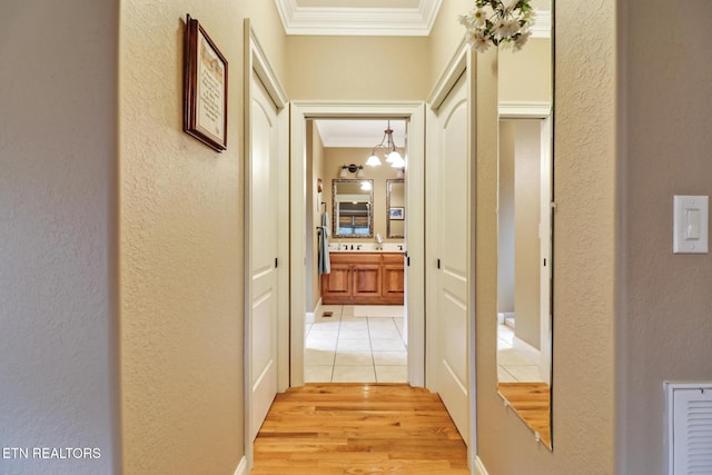 hall featuring ornamental molding and light hardwood / wood-style floors