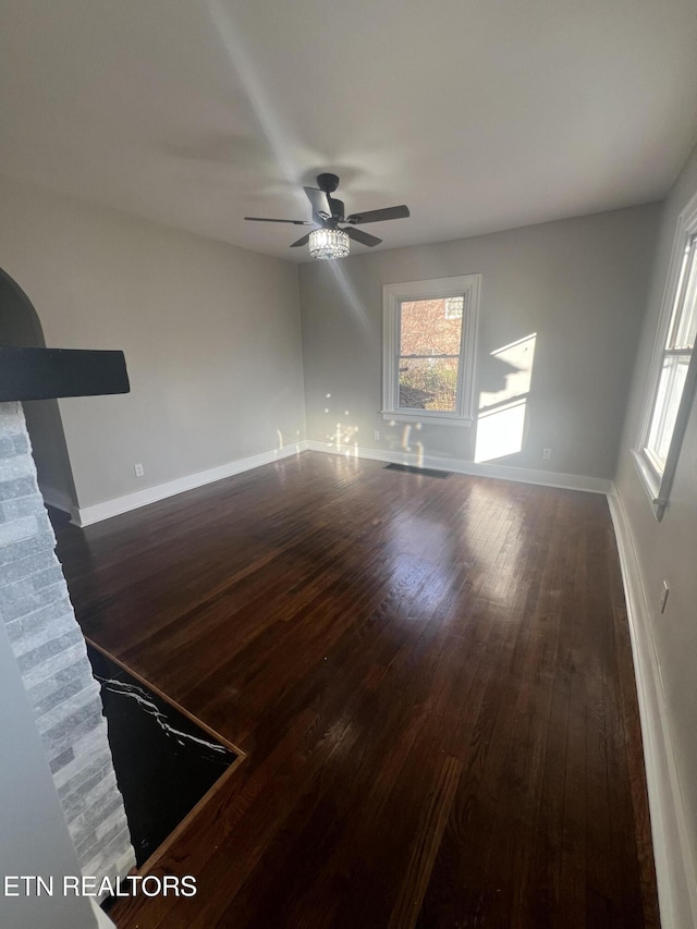 unfurnished room with dark wood-type flooring and ceiling fan