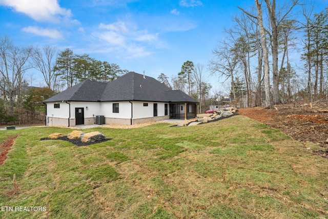 back of property featuring cooling unit, brick siding, a shingled roof, a patio area, and a lawn