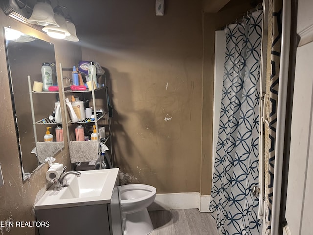 bathroom with vanity, wood-type flooring, and toilet