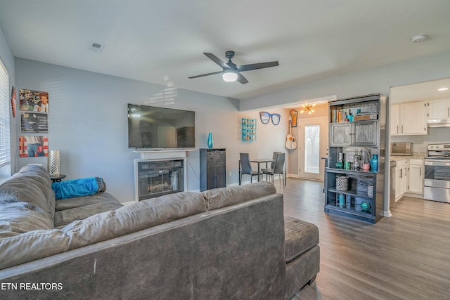 living room with light hardwood / wood-style flooring and ceiling fan