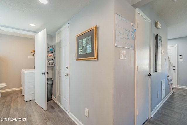 corridor featuring washer / clothes dryer and hardwood / wood-style floors