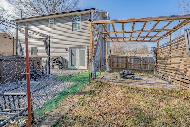 rear view of property with a pergola, a fire pit, and a patio area