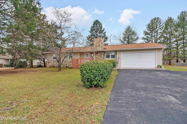 single story home featuring a wooden deck, a garage, and a front yard