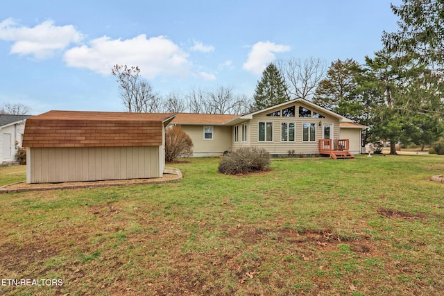 back of property with a wooden deck and a yard