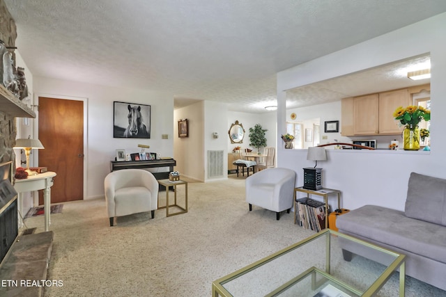 carpeted living room featuring a textured ceiling and a fireplace