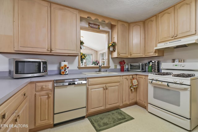 kitchen featuring lofted ceiling, sink, a textured ceiling, light brown cabinets, and white appliances