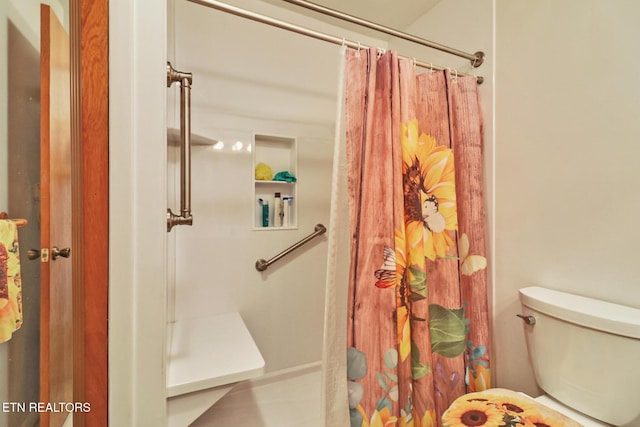 bathroom with a shower with curtain and toilet