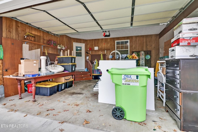 garage with a garage door opener and wooden walls