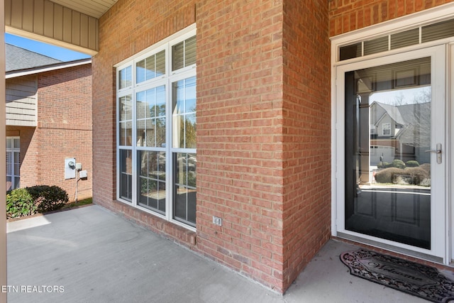 entrance to property featuring brick siding