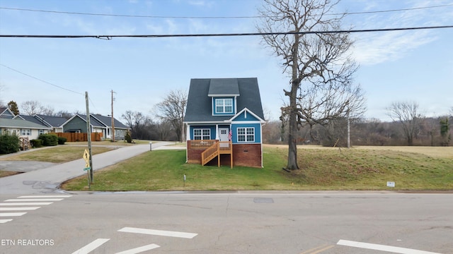 view of front facade with stairs and a front yard